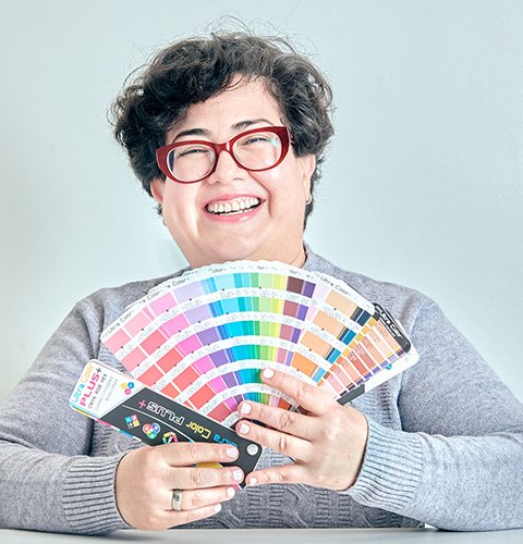 coach vocacional que tiene un pantone en su mano abierto como un abanico para representar su parte como diseñadora